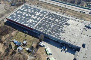 Ряды солнечных панелей на плоской крыше коммерческого здания